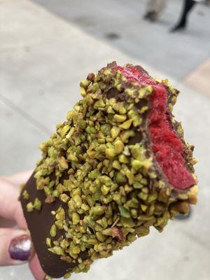 Raspberry dipped in dark chocolate rolled in pistachios