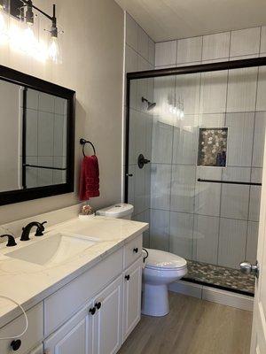 Master bath. Removed tub installed new shower, countertop lights mirror and vinyl tile throughout unit