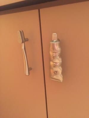 Toothbrush and toothpaste handles on cabinets. Aw!