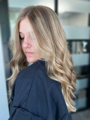 Blonde balayage with a bright pop of face framing highlights