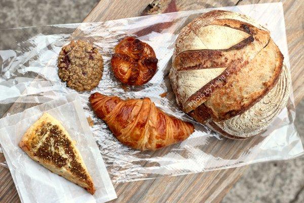 Feta-Za'tar Scone ($4.90), Kouign-Amann ($5.20), Croissant ($4.70), Cherry Oat Cookie ($3), 1/2 Fig-Walnut Loaf ($6.50), 1/2 Sourdough ($6)