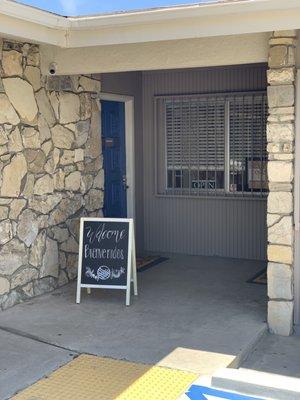 The entrance to the clinic. Hours are posted next to (open/close) sign.