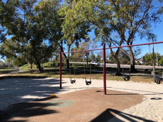 Toddler swings next to baseball diamond