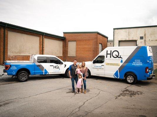 Owners of HQ Water Solutions water treatment company standing in front of company vehicles