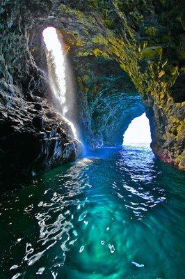 Inside the Double-door cave, waterfall streams from a hole in the cave's ceiling