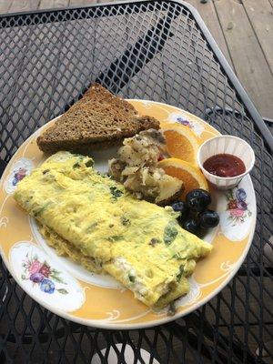 Omelette, grain toast, potatoes, fresh fruit.