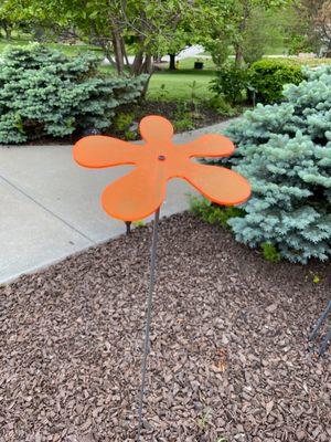 An orange flower shaped garden decoration.