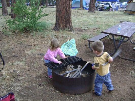 The kids helping build a fire.