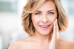 Desert Dermatology & Skin Cancer Specialists - woman smiling with hand on face