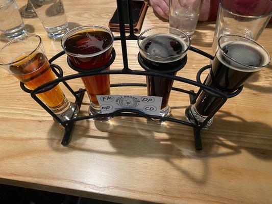 Flight of darker beers in a great holder for the glasses.