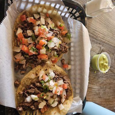 Carne asada tacos with added pico and guac salsa on the side.