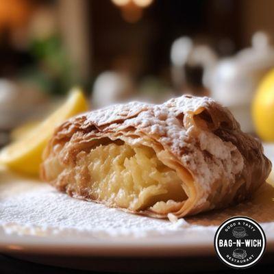 Enjoy a flaky apple turnover, dusted with sugar - a sweet bite!