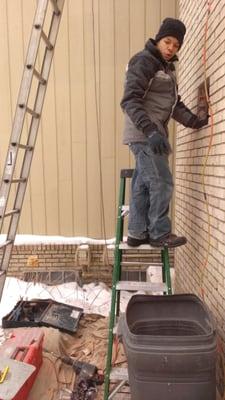 Removing broken flue tile shards from a chimney fire in preparation for a stainless steel flue relining.