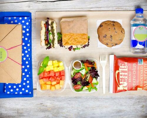 Our deluxe lunch box. Packed with a full sandwich, fresh baked cookie, bottled water, fruit salad, garden variety salad and a bag chips.