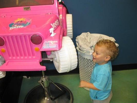 Post-trim, Samson checks out the Barbie jeep chair, one of the many fun options for seating during a KAOS haircut.