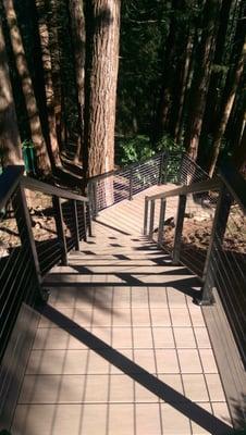 Staircase built out of PVC Wolf Decking with Aluminum cable railing for unique access to the back yard.