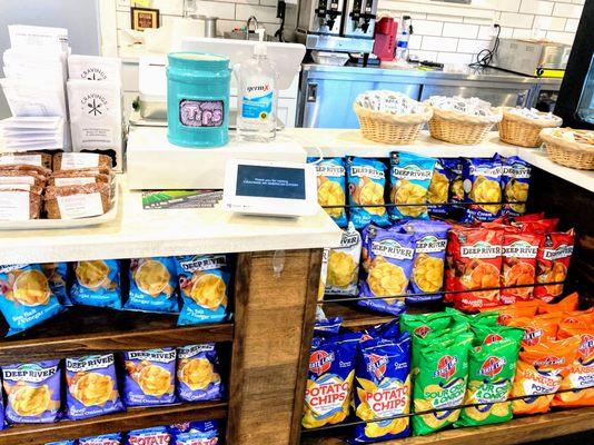 Close up of the check out counter, with sanitzer, tip jar, and STATE LINE CHIPS!!