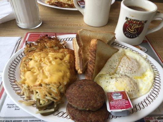 Two eggs over medium with sausage patty and hash browns.