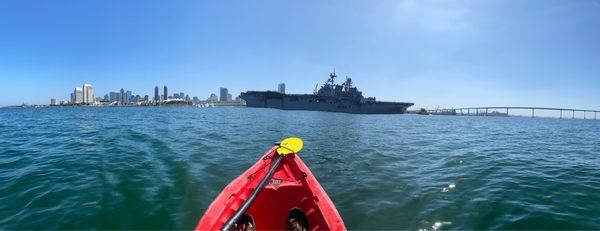 In a kayak, watching a military carrier pass by and downtown San Diego in the background.