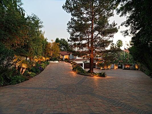 Paver driveway remodel with ambient outdoor lighting and updated landscape design.