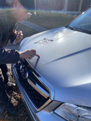 Him cleaning the epoxy off my hood.