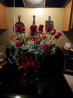 A dozen roses with carnations and baby's breath.