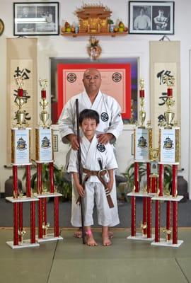 Shihan Kai Leung with student Aidan Lok and his four first place trophies from the 2013 US Capitol Classic NASKA 6A tournament.