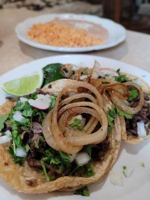 Steak tacos Mexican style with beans and rice.