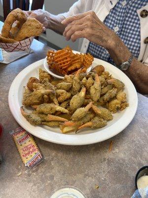 Seafood platter with crab claws, shrimp, fish, and sweet potato fries.