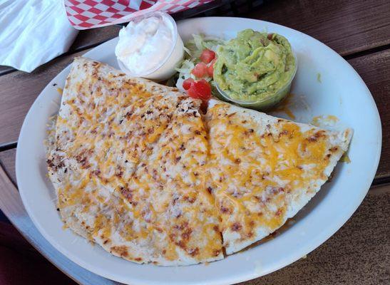 A quesadilla with chicken, sour cream, guacamole, and all the right flavors.