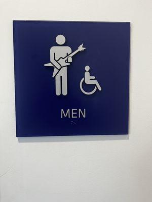 Kick ass sign by the bathroom but the handicapped dude should have a drum set