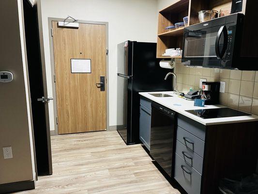 Front entrance with refrigerator, kitchenette and closet.