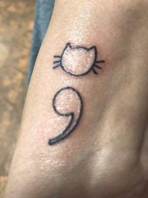 Cat semicolon on wrist.