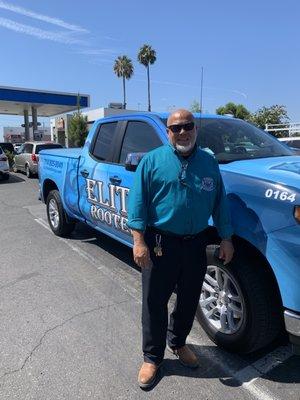 Elite Rooter technician standing proudly by the company truck, ready to deliver exceptional plumbing services.