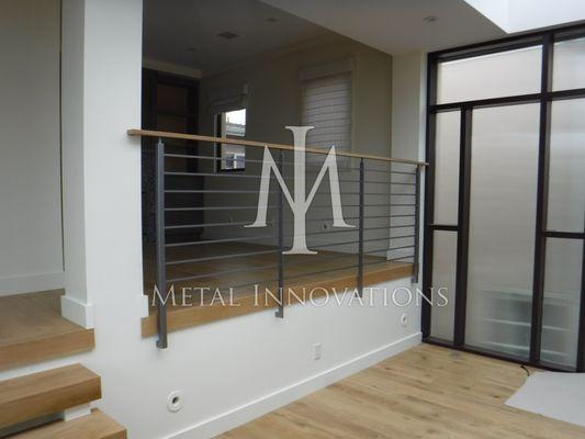 Horizontal Rod Rail with combination wood to rail, side mounted with recessed mounting base plates. Located in Manhattan Beach, CA