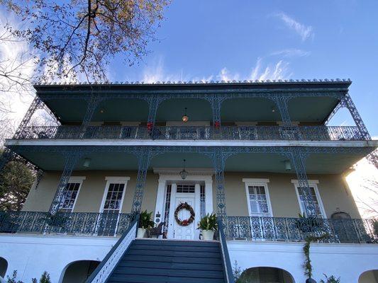 The mansion. The rooms are on the first floor under the steps.