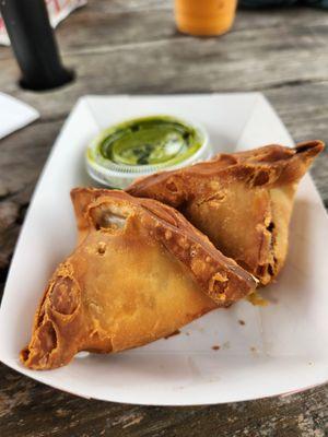 Samosas, served with a side of mint sauce.