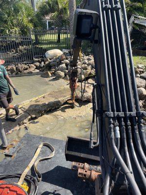 Drilling into rock in order to set pilings for dock.