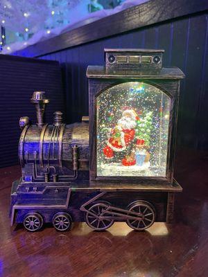 The charming Santa-on-a-train actual snow globe on our table top.