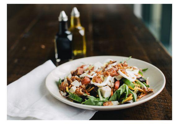 Chef Salad mixed greens, Ovengold® Turkey, Bacon, cheddar, tomato, cucumber, carrots, egg, choice of dressing