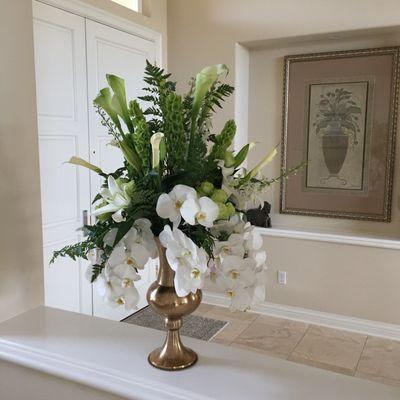 Memorial arrangement with white phalaenopsis orchids, white calla lilly, green bells, lily's and greenery.