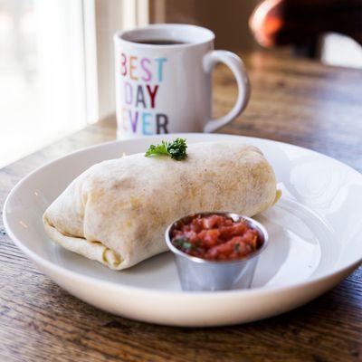 Breakfast burrito with eggs, potatoes, bacon, colby jack cheese, salsa verde and red of salsa.