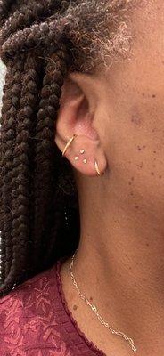 Triangle piercing with gold discs.