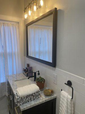 Custom mirror vanity on a sliding track with shelves and a hidden outlet inside. Just need my window treatment to install!