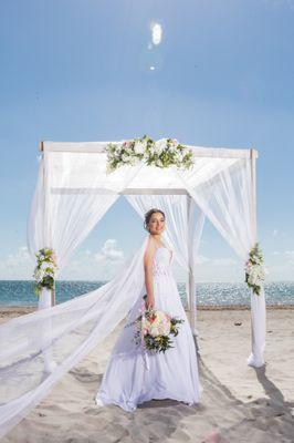 Beautiful Bride with a custom floral design on a 4 post bamboo arbor.