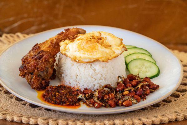 Nasi Lemak -- traditional Malay dish featuring fragrant coconut rice, fried chicken wing, sambal ikan bilis, cucumbers, and a fried egg