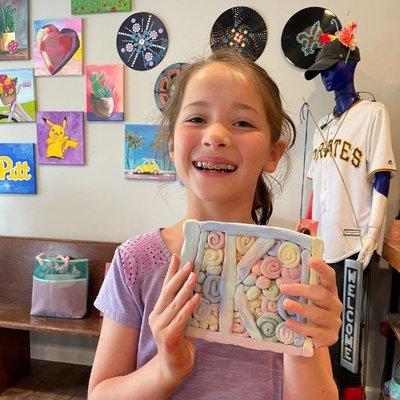 young artist smiling with her clay creation!