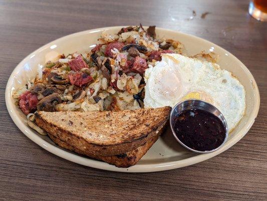 Corned beef hash with mushrooms, eggs over-medium, wheat toast, and jelly