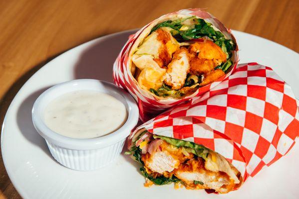 Fried chicken wrap with buffalo sauce, lettuce, onion, cucumber, cheddar cheese, Ranch and a choice of side