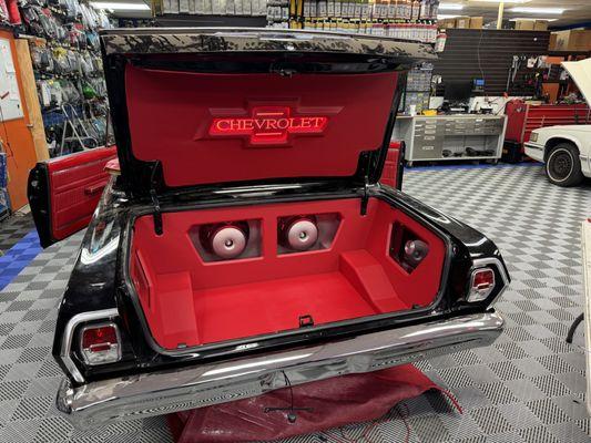 1962 Chevy Nova with a custom trunk wrapped with red cloth bringing it to life with a full JL Audio system